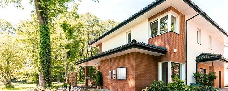 Solar Panels in Power Outage Brown and White House with Trees Outside View